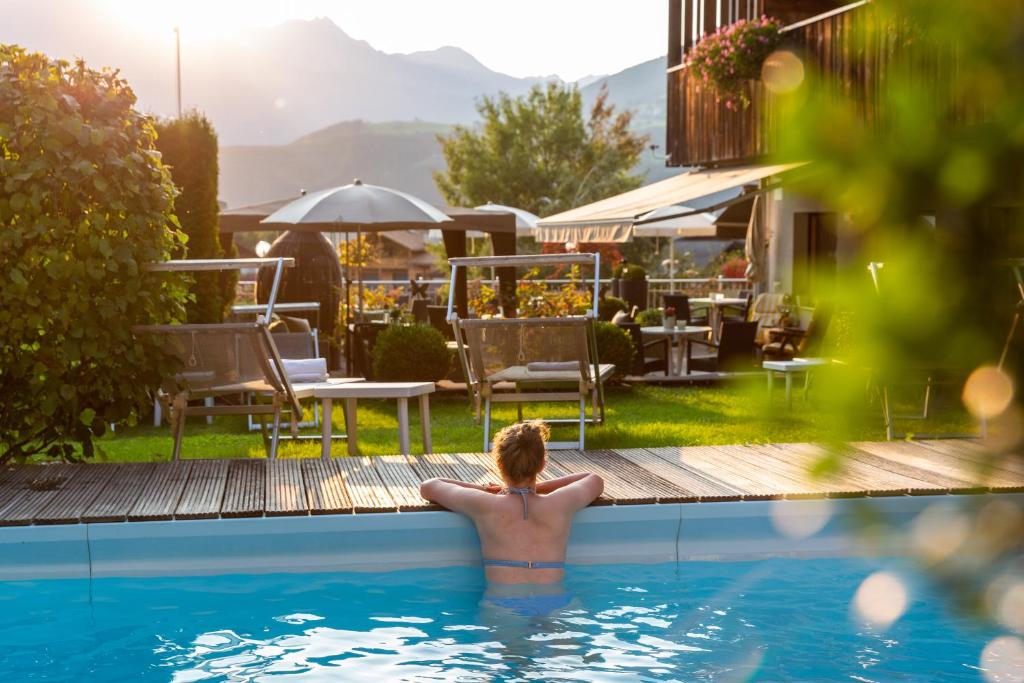 a man in the swimming pool at a hotel at Hotel Tirolerhof in Rodengo