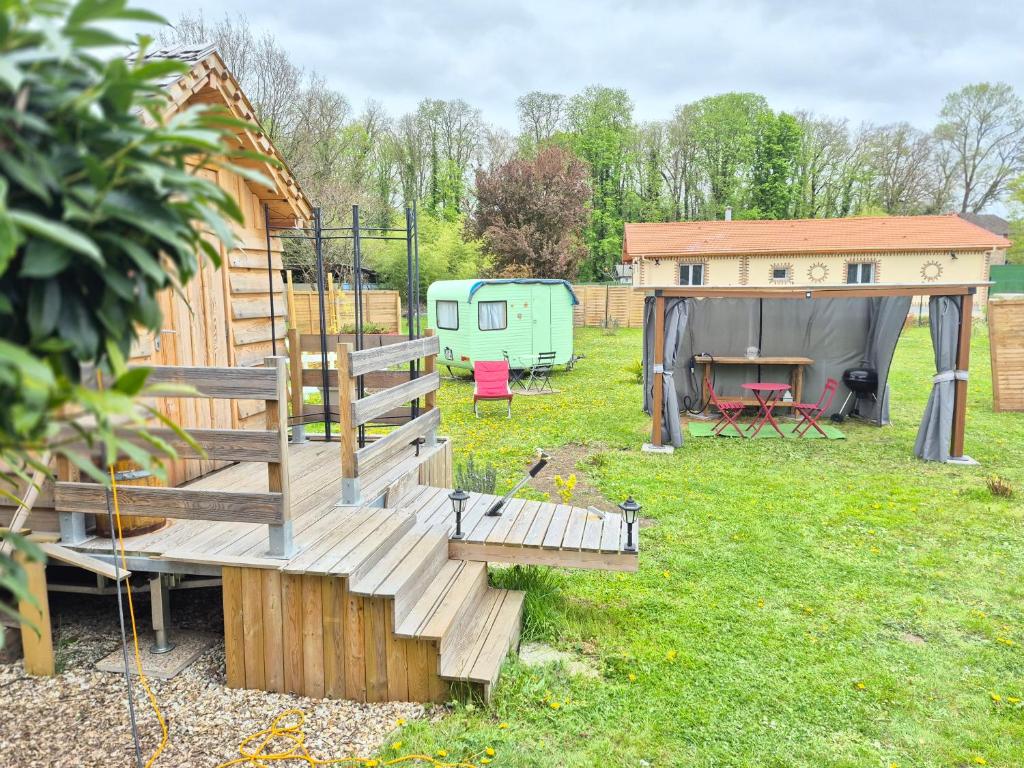 a wooden deck with a trailer and a tent at Le cocon de Lili et de Patrick in Draveil