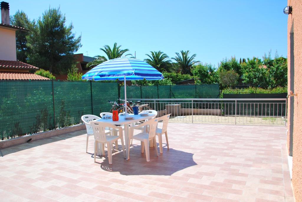 una mesa y sillas con una sombrilla en el patio en Appartamenti Margherita, en Campo nell'Elba