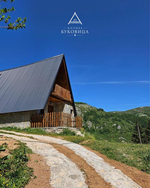 a barn on a hill with a dirt road next to it at Koliba BUKOVICA in Šavnik