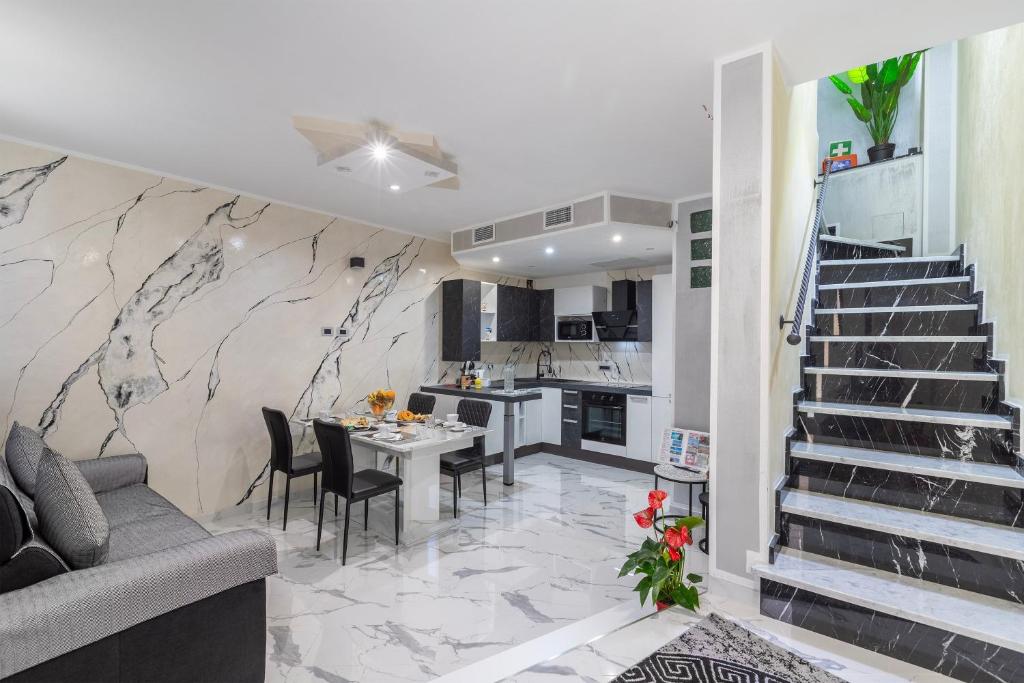 a kitchen and dining room with a staircase in a apartment at Prestige House in Nulvi