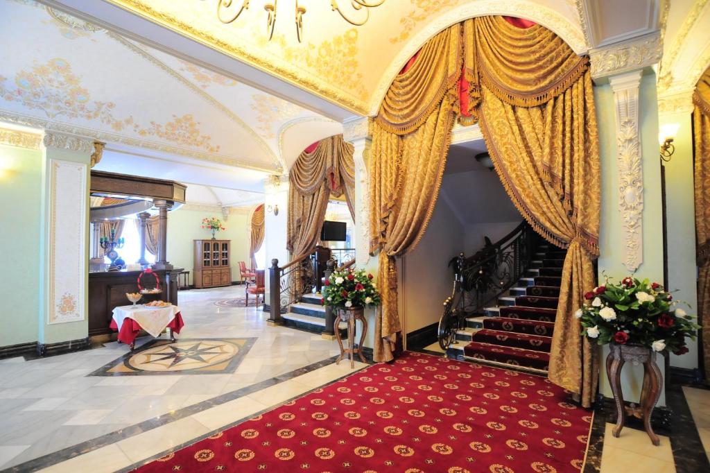 un couloir avec une moquette rouge et des escaliers dans un bâtiment dans l'établissement Boutique Hotel Traditional, à Astana