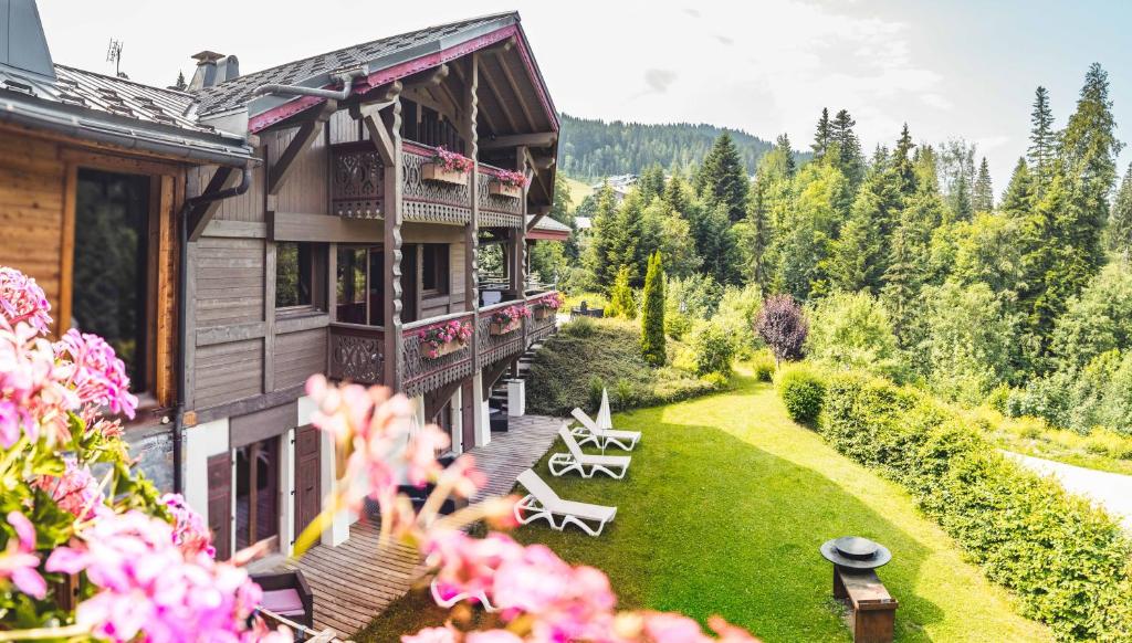 a house with a yard with chairs and flowers at Chalet Adelphine 1 & SPA in Les Gets