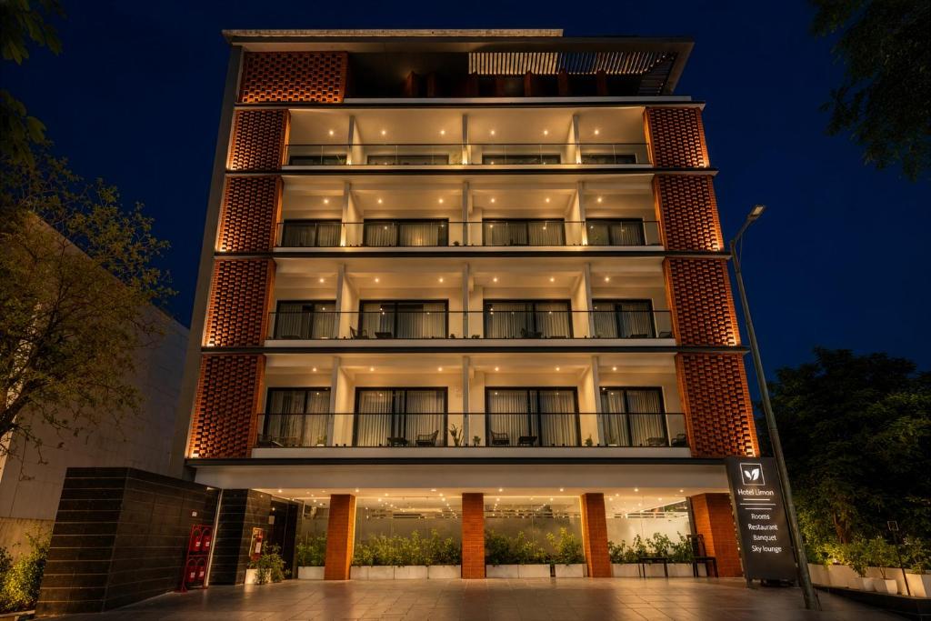 a tall building at night with its lights on at Hotel Limon Sector 45 Gurgaon in Gurgaon