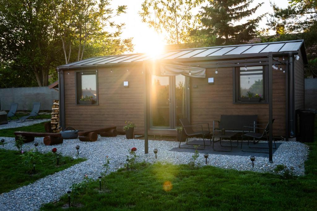 a small cabin with a table and chairs in a yard at Tisza-tavi Kiserdő Lodge in Tiszaderzs