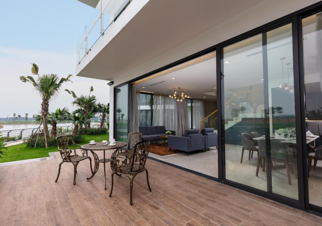 a patio with glass doors and a table and chairs at DIC Star Villas Vinh Phuc in Vị Trù