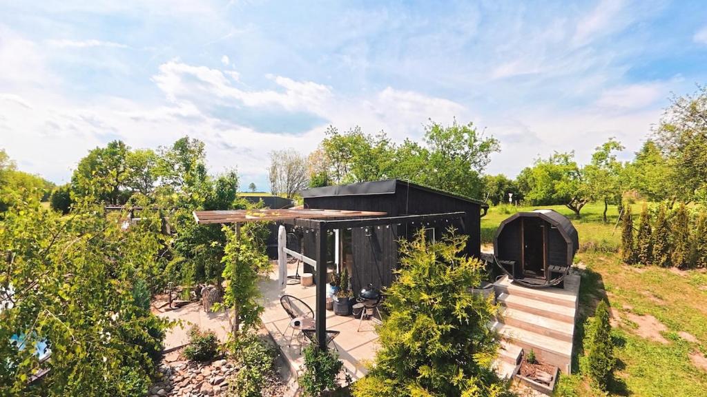 a black building in a field with trees at Garden Residence - The Nest in Drahobudice
