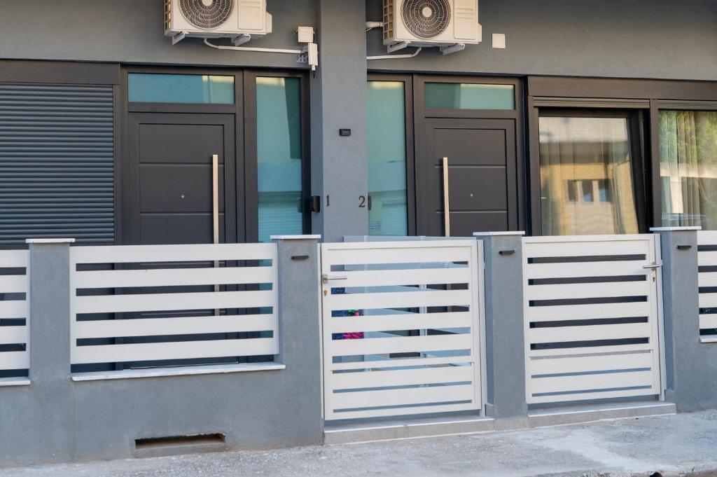 a white fence in front of a building at DNS Elements Apartments 2 in Nea Karvali