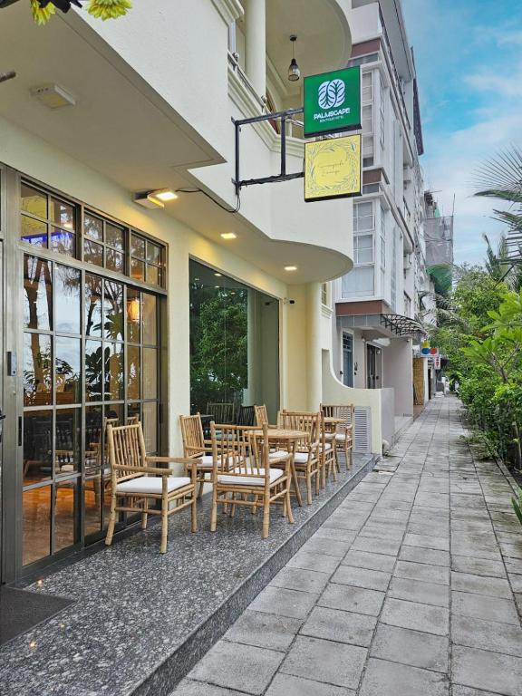 a row of tables and chairs outside of a building at Palmscape Boutique Hotel in Hulhumale