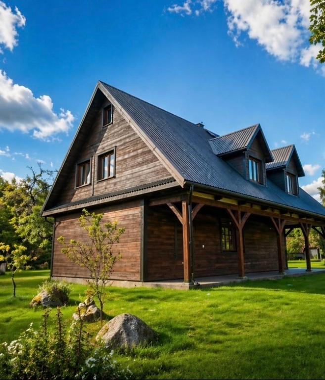 a large wooden barn with a gambrel roof at Jakubowo in Długi Bród