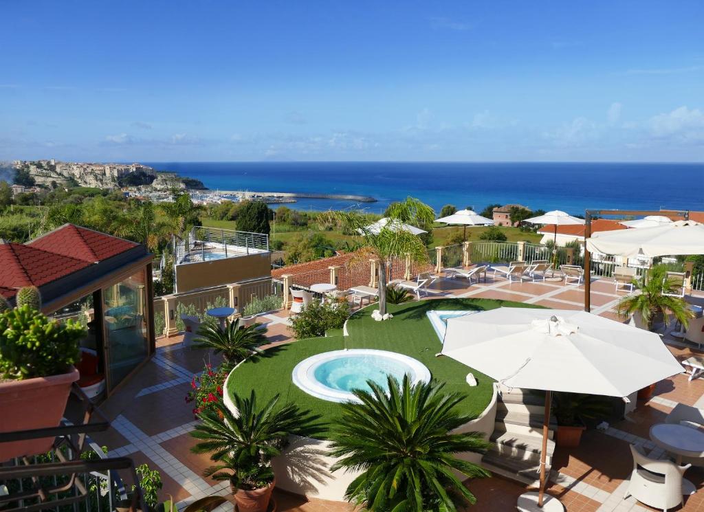 帕爾蓋利亞的住宿－Hotel Residence Piccolo，享有带游泳池和遮阳伞的度假村景致