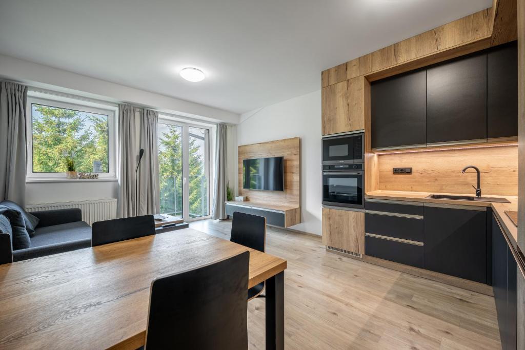 a kitchen with a table and a living room at Visit sauna Klinovec in Loučná pod Klínovcem