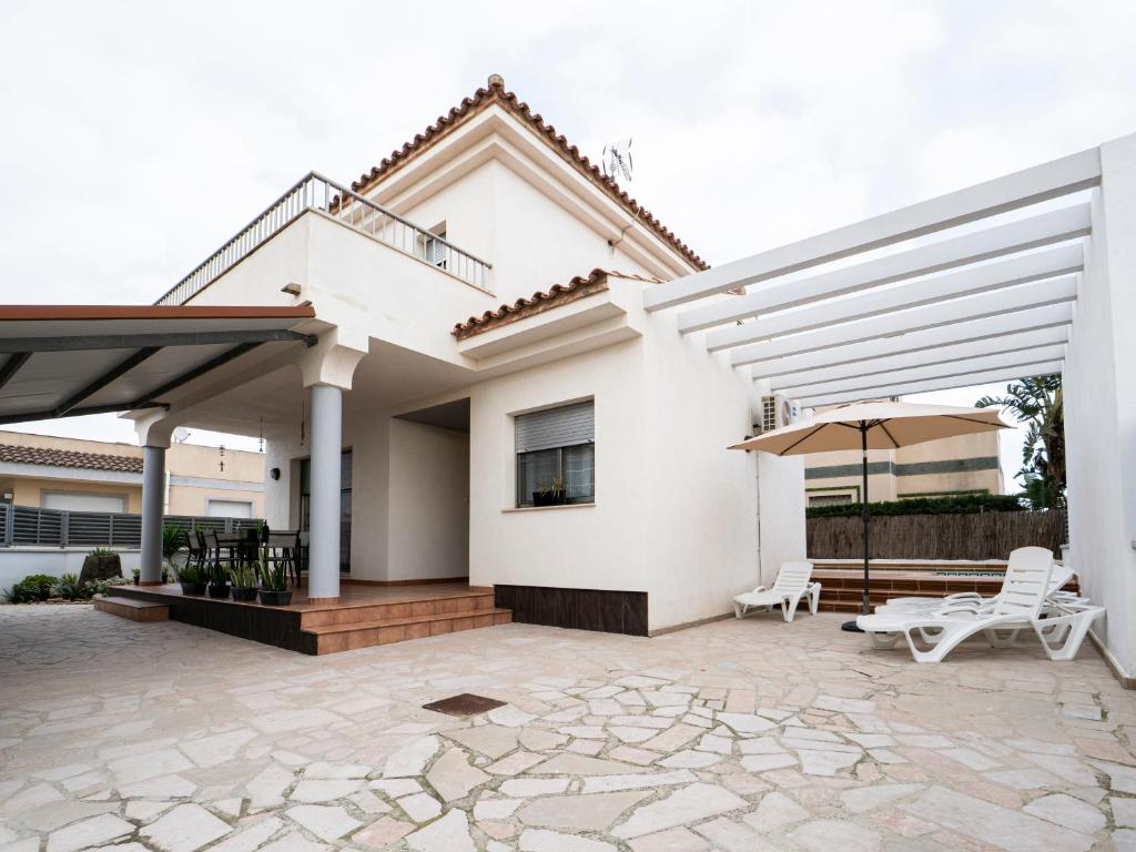 a white house with a patio and an umbrella at Villa Joan in Riumar