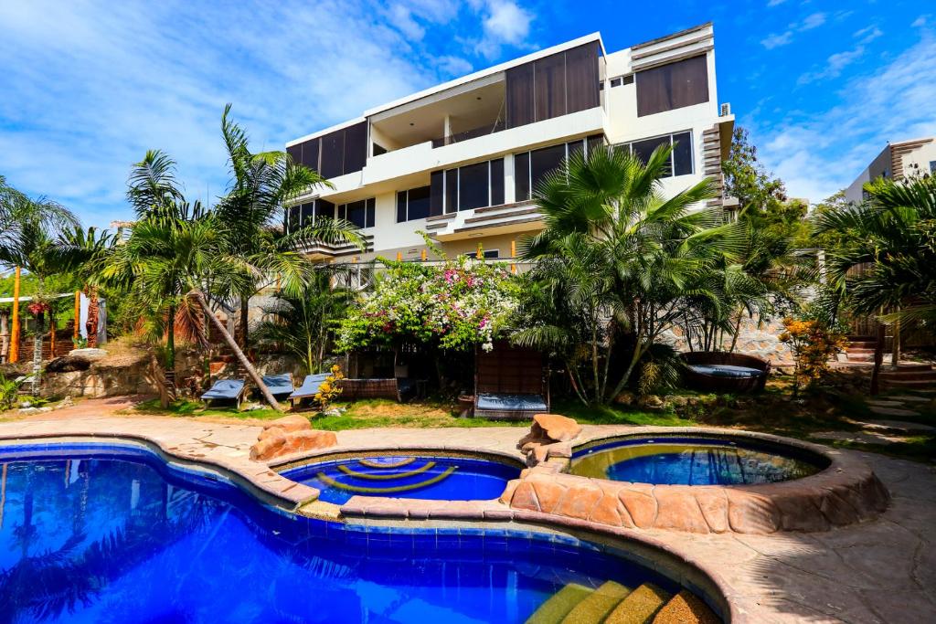 a resort with two pools and a building at ME Hotel & Villas - Montañita Estates in Montañita