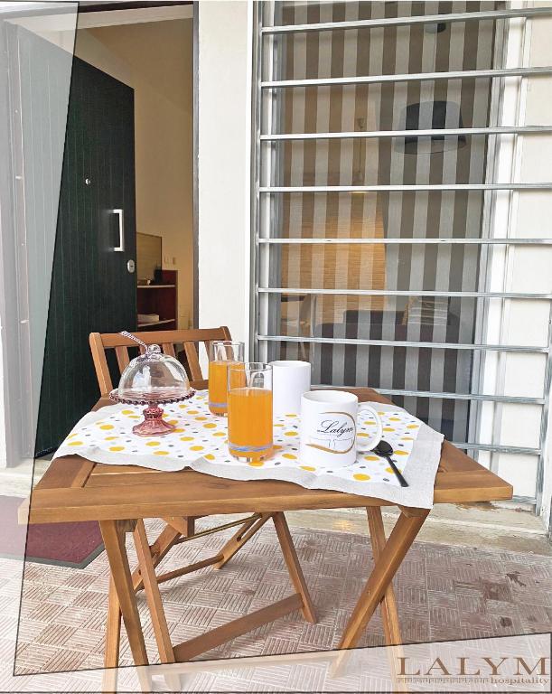 a wooden table with glasses of orange juice on it at Lalym Donnanna Apartment in Rossano Stazione