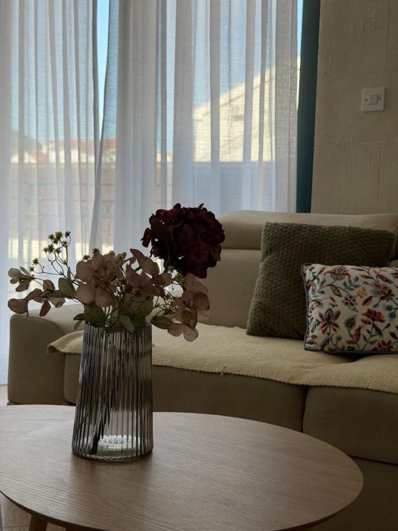 a vase of flowers on a table in a living room at Novia Apartment 22 in Đenovići