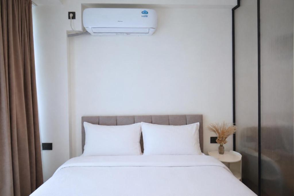 a bedroom with a large bed with white sheets at Chic city apartment I By Domel Yerevan in Yerevan