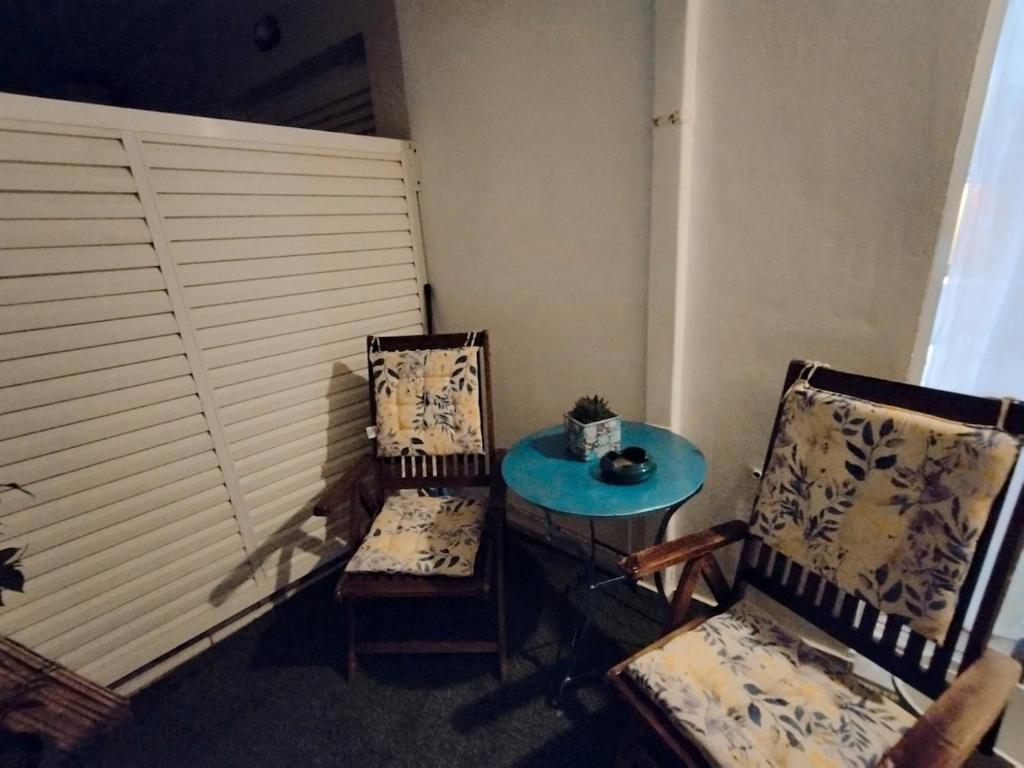 a room with two chairs and a blue table and two chairs at Cucuvaya Rithy in Áyios Andónios