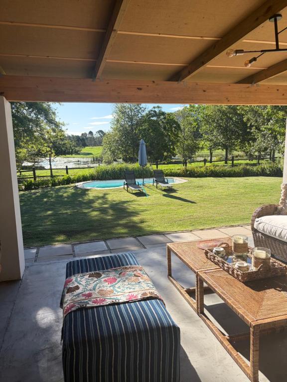 a patio with a table and a view of a yard at Bayerley in Plettenberg Bay