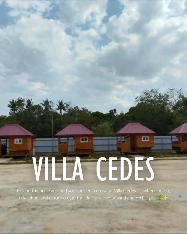 a sign that reads villa cottages with trees in the background at Villa Cedes in Lasam