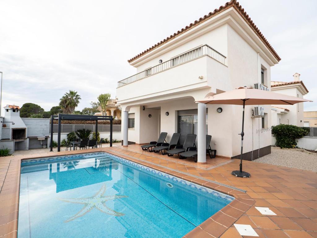 a house with a swimming pool and an umbrella at Villa Victor in Riumar