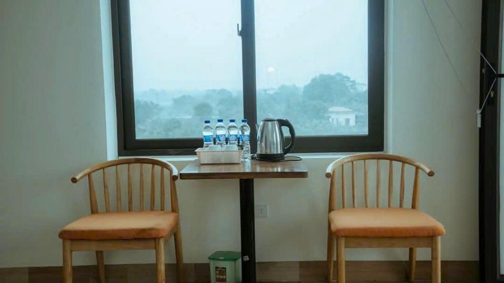 two chairs and a table with bottles of water on it at Tam coc Sylvani Homestay in Vũ Lâm