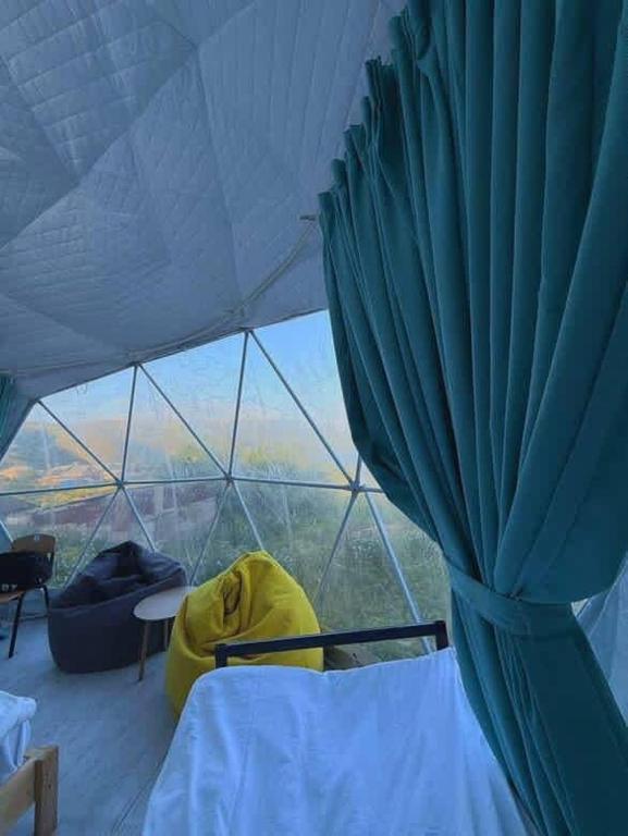 a room with a tent with a bed and a window at Lakeside glamping in Tsovagyugh