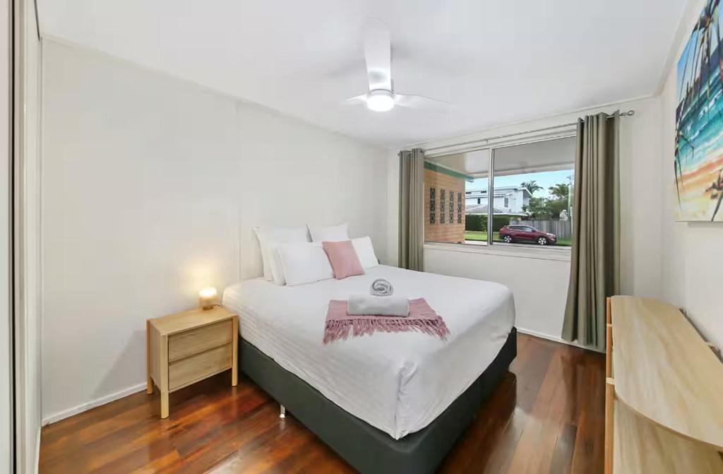 a bedroom with a large bed and a window at Beach Side on Burke - Pet Friendly in Golden Beach