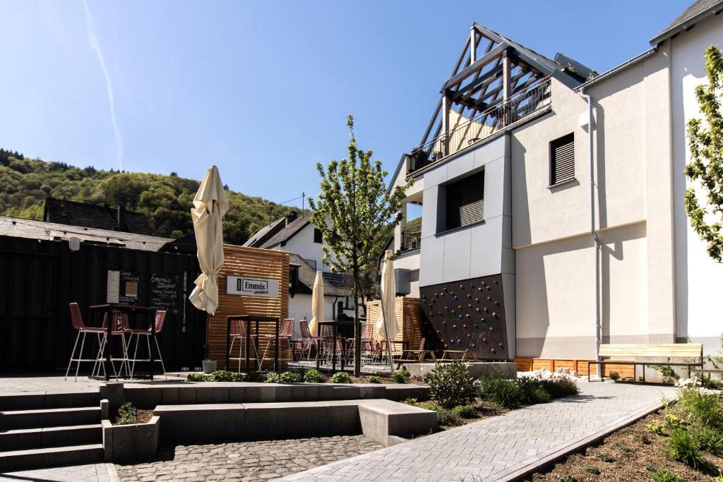 ein Haus mit Terrasse und Sonnenschirm in der Unterkunft Emmis Appartements in Bremm