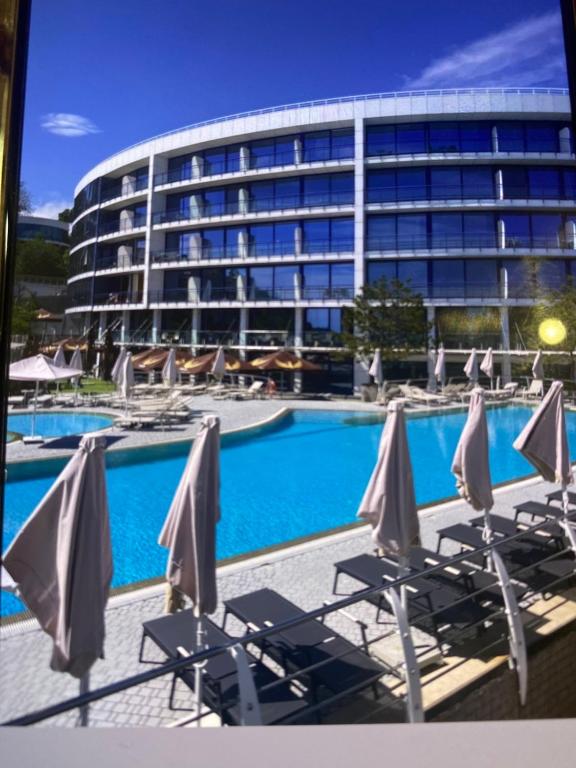 a swimming pool with chairs and a building at Blu Mare Residense in Odesa