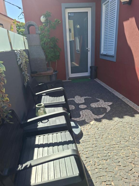 a pair of benches sitting outside of a house at Palheiro do Fontenário in Funchal