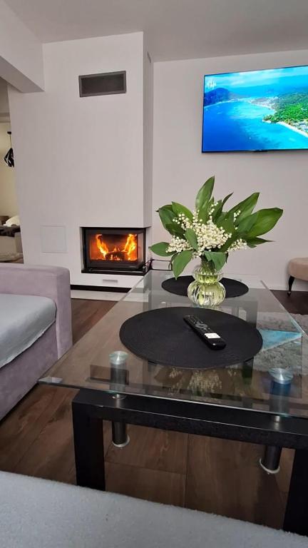 a living room with a table and a fireplace at Noclegi Leśne Bagno in Zwierzyniec