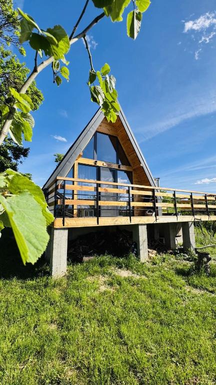 a building with a roof on top of a field at Secluded A-Frame Cabin with Private Hot Tub & Views - IezerVenture in Şelari