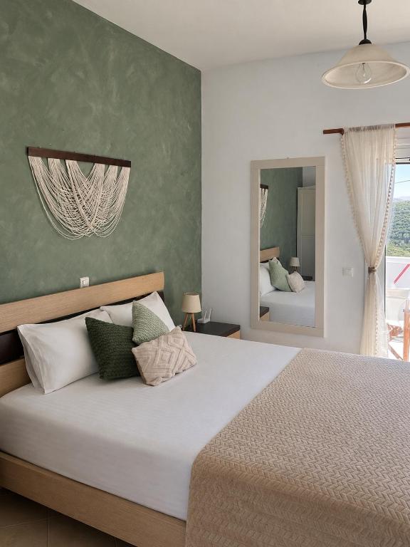 a bedroom with a large bed and a mirror at Elia II in Kondoliánika