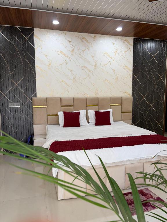 a bedroom with a large bed with red pillows at Hotel Lotus Stay INN in Jabalpur