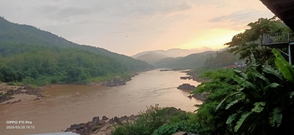 a view of a river with mountains in the background at Mekong Backpackers in Pakbeng
