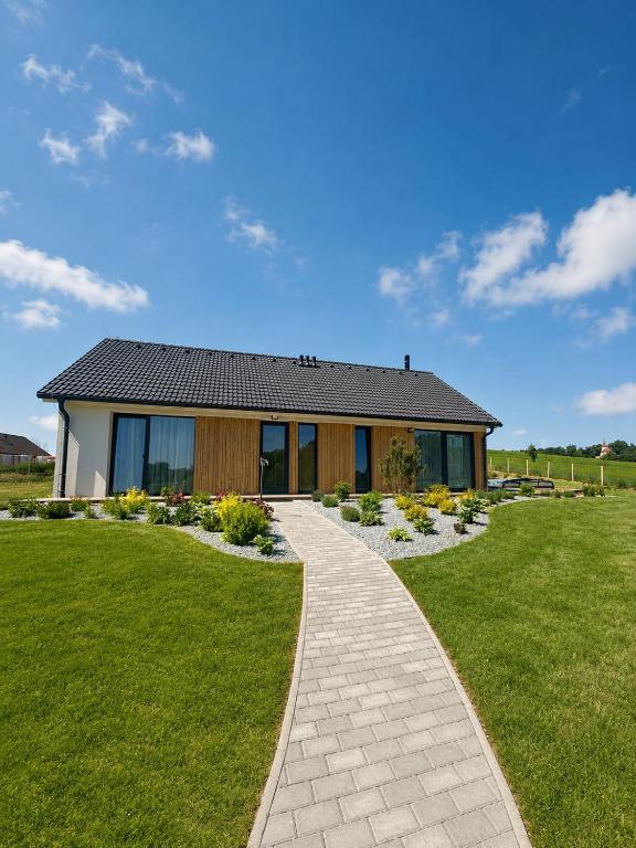 a house with a walkway in front of a yard at Modern House with Private Pool & Terrace in Červená Třemešná