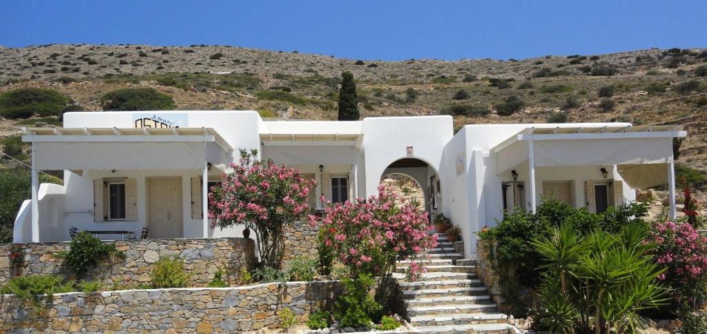 a white house with flowers in front of it at Agnanti studios - sikinos in Síkinos