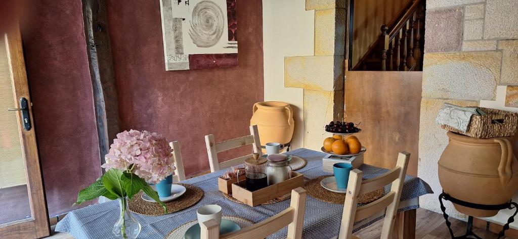 a table with a blue table cloth and vases on it at La Senda del Norte in Cabezón de la Sal