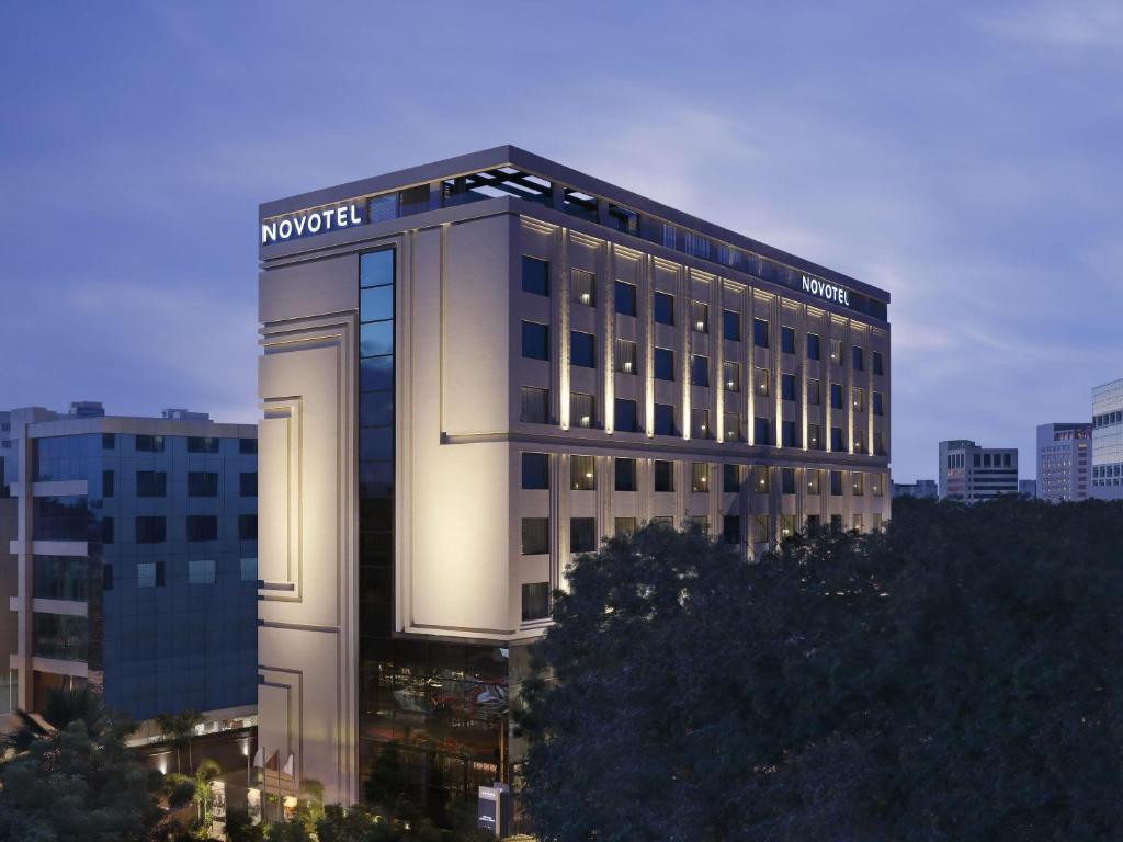 a building with a sign on the side of it at Novotel Chennai Chamiers Road in Chennai