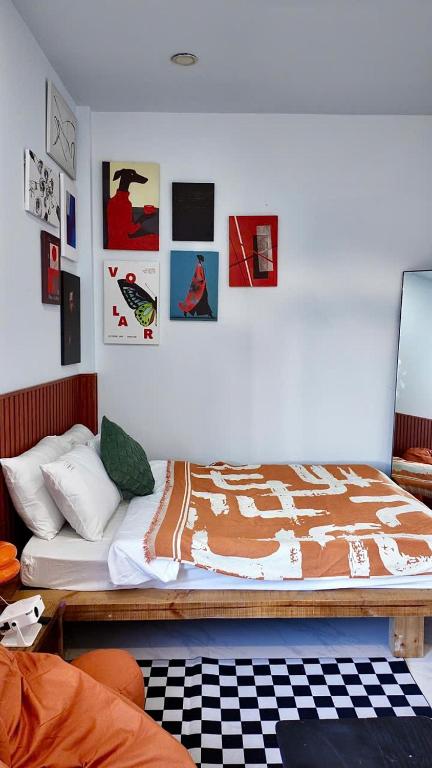 a bedroom with a bed with pictures on the wall at Tổ Ấm 25 in Da Thanh