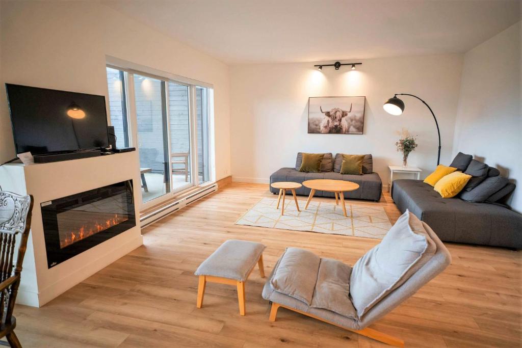a living room with a couch and a fireplace at Chic Condo - Stunning View & Quiet in Baie-Saint-Paul