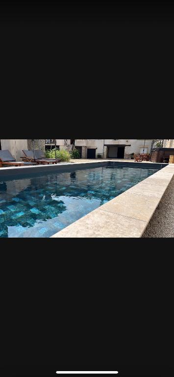 a picture of a swimming pool with blue water at « Le Clos de la Côte d’Or » in Ladoix Serrigny