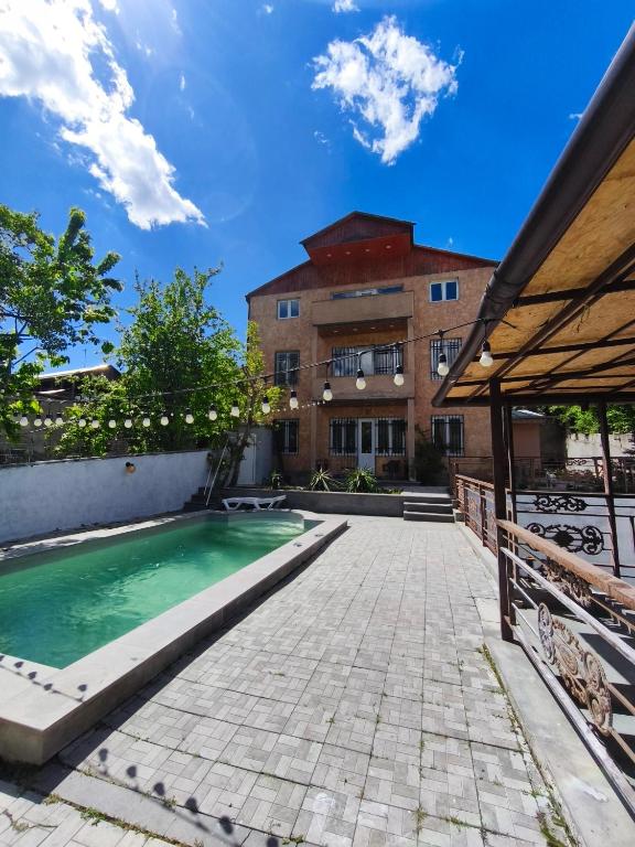 a swimming pool in front of a building at Dilijan Rest - Comfortable rooms & Pool in Dilijan