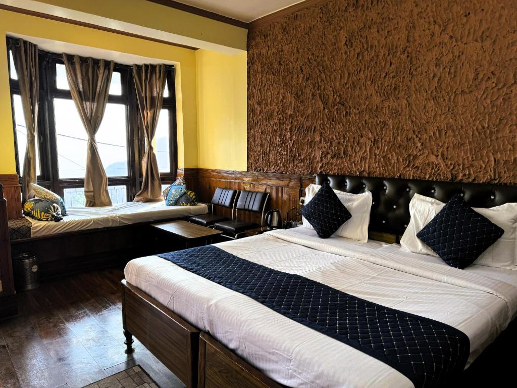 a hotel room with two beds and two windows at Hotel Monal Inn, Pangot Wildlife and Bird Sanctuary in Nainital
