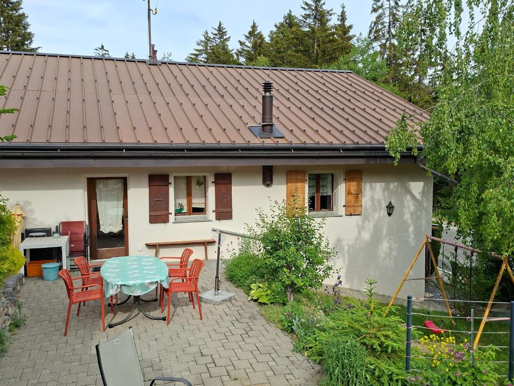 a small white house with a table and chairs at Les loulou 2 in Savièse