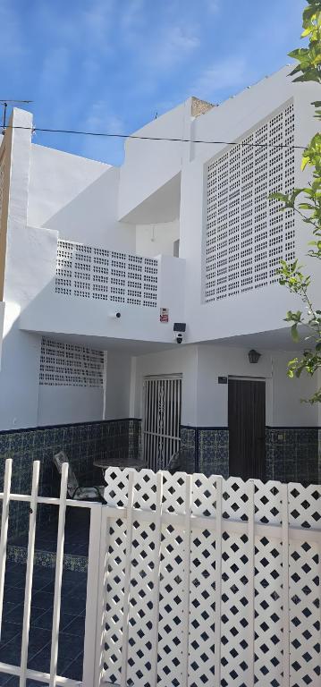 a white building with a fence in front of it at Marolesja in Puerto de Mazarrón