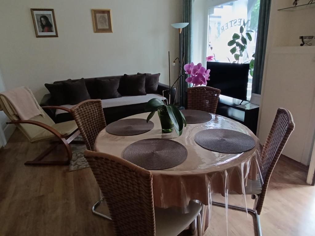 a living room with a table with chairs and a couch at Céhmesterek apartman in Eger