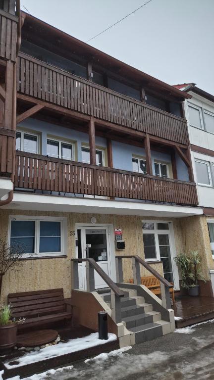 a apartment building with a staircase and a balcony at Nad Hrází I in Lipno nad Vltavou