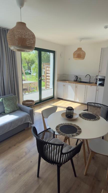 a living room with a table and chairs at Liwia Park Green House in Niechorze